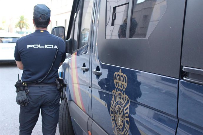 Agente de Policía Nacional junto a furgón policial en València