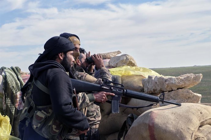 Archivo - FILED - 13 February 2019, Syria, ---: Soldiers of the Manbij Military Council (MMC) a subsidiary of the Syrian Democratic Forces (SDF), a US-allied Kurdish-led rebel group, guard a pathway for families who fled the fighting with the so-called Is