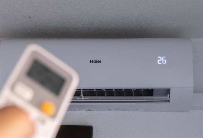 Una persona enciende un aire acondicionado.