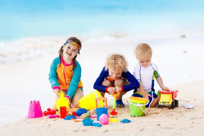 Archivo - Niños jugando en la arena de la playa