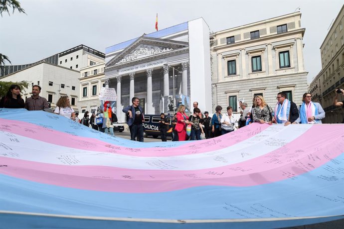 Archivo - Arquivo - Várias pessoas seguram a bandeira trans que a Federación Estatal de Lesbianas, Gais, Trans, Bisexuales, Intersexuales y más (Flegtbi+), Chrysallis e Fundación Triángulo levaram ao Congresso dos Deputados, em 27 de outubro de 2022, em M