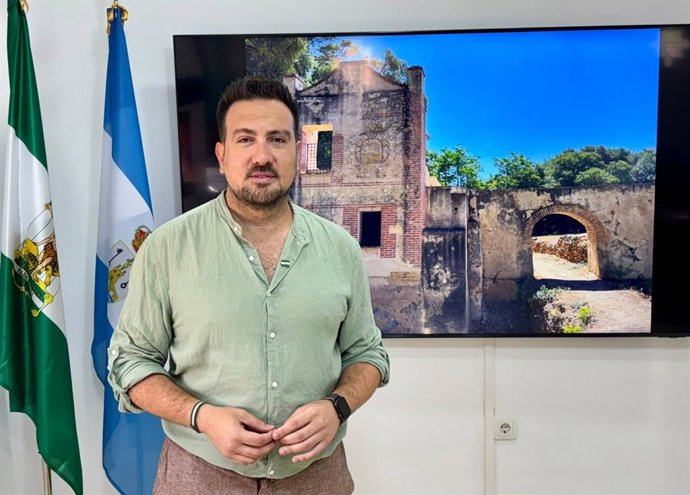 El delegado municipal de Patrimonio, Cultura y Turismo, Christopher Rivas, frente a una imagen del Molino de La Tapada.