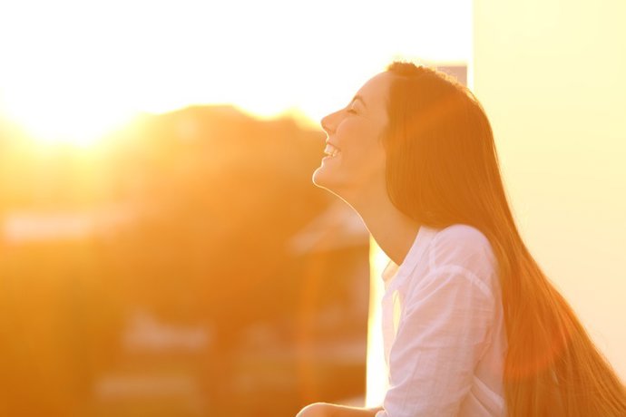 Archivo - Woman breathing at sunset in a balcony