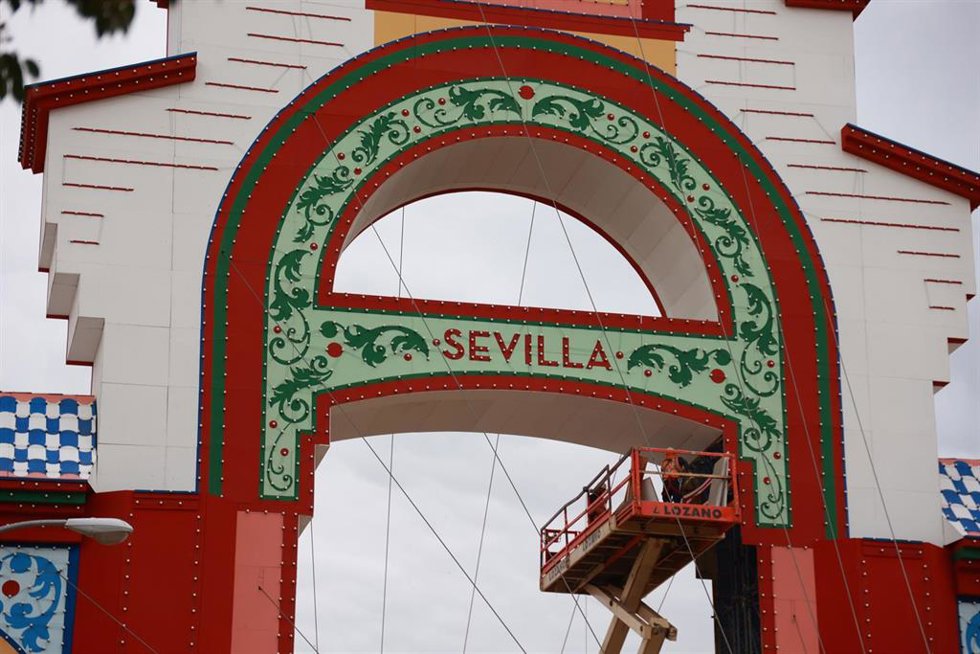 Archivo - Varios trabajadores en la portada de la Feria de Sevilla.