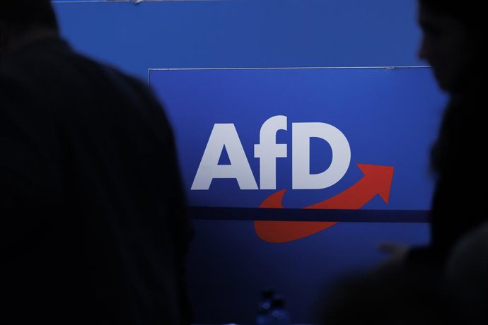Archivo - FILED - 28 July 2023, Saxony-Anhalt, Magdeburg: People walk in front of the party logo at the Alternative for Germany (AfD) party conference in Magdeburg. Photo: Carsten Koall/dpa