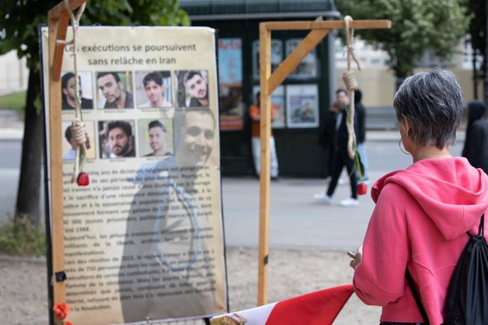 Archivo - Arquivo - 13 de maio de 2025, Paris, França: Uma mulher olha para os retratos das vítimas de execuções no Irã durante o comício. Apoiadores do Conselho Nacional de Resistência do Irã (NCRI) e associações franco-iranianas organizam uma manifestaç