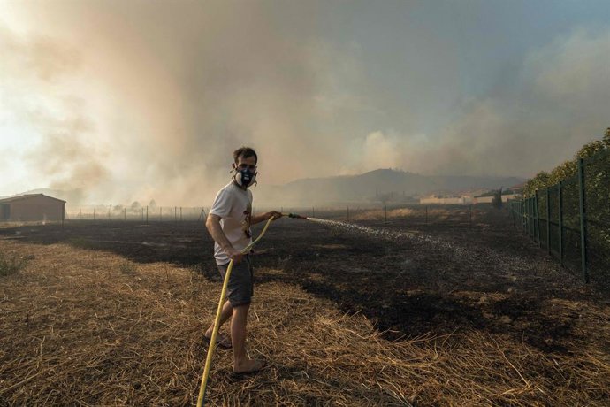 Imagem de arquivo de um homem tentando apagar um incêndio na França.