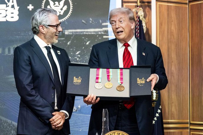 05 de agosto de 2025, EUA, Washington: Casey Wasserman, presidente do comitê organizador das Olimpíadas de Los Angeles de 2028, presenteia o presidente Donald Trump com medalhas para as Olimpíadas de Los Angeles de 2028 durante a assinatura de uma ordem e