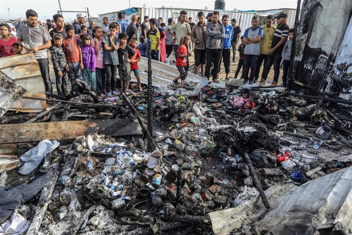 Archivo - Palestinos inspeccionan tiendas de campaña destruidas por un bombardeo del Ejército de Israel contra la "zona humanitaria" de Al Mauasi, en la Franja de Gaza (archivo)