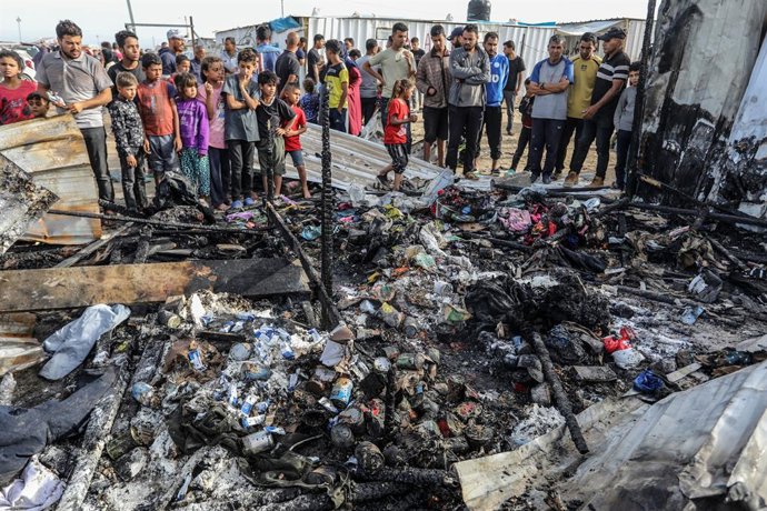 Archivo - Arquivo - Palestinos inspecionam barracas destruídas por bombardeios do exército israelense na "zona humanitária" de Al Mauasi, na Faixa de Gaza (arquivo).