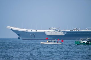 HONG KONG, July 7, 2025  -- Local people taking ferries see off the Chinese People's Liberation Army (PLA) Navy fleet in Hong Kong, south China, July 7, 2025. A fleet of the Chinese People's Liberation Army (PLA) Navy, led by the aircraft carrier Shandong