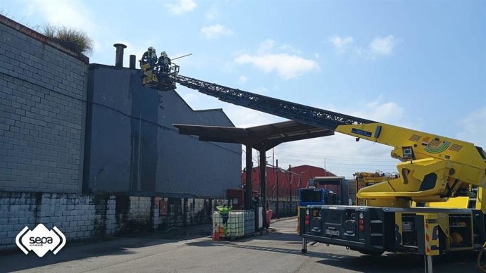 Bomberos intervienen en el incendio en una empresa de la calle Conde Guadalhorce de Avilés.