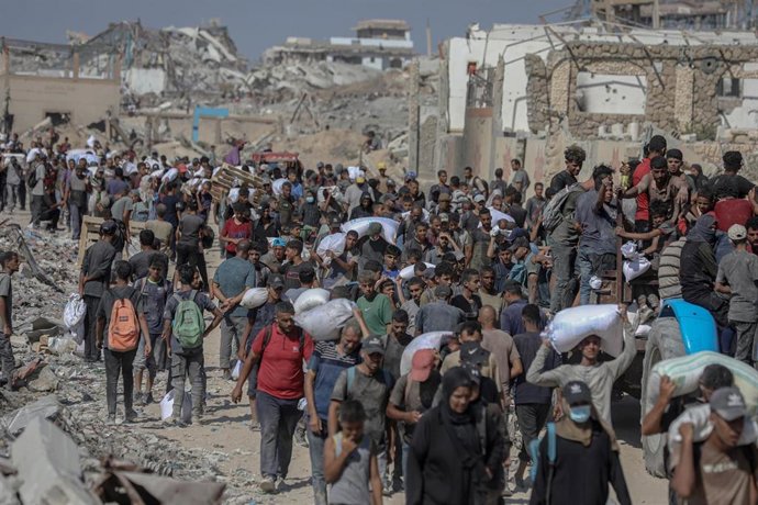 August 5, 2025, Gaza City, Gaza Strip, Palestinian Territory: Palestinians carry aid supplies that entered Gaza through Israel, in Beit Lahia in the northern Gaza Strip, on August 5, 2025