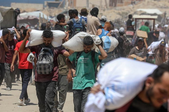 1º de agosto de 2025, Cidade de Gaza, Faixa de Gaza, Território Palestino: Palestinos carregam sacos de farinha que obtiveram de caminhões de ajuda que entraram em Gaza pelo ponto de passagem de Zikim, em Jabalia, no norte da Faixa de Gaza, em 1º de agost