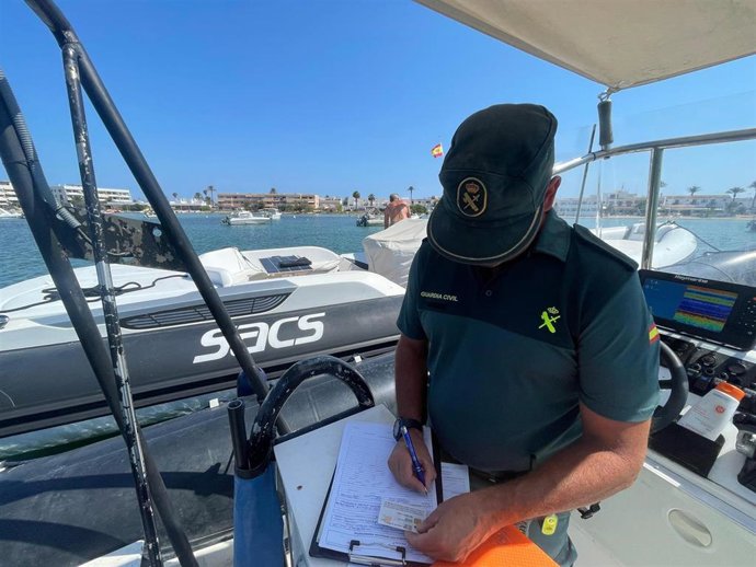 Un agente de la Guardia Civil levanta un acta por fondeo ilegal en Formentera.