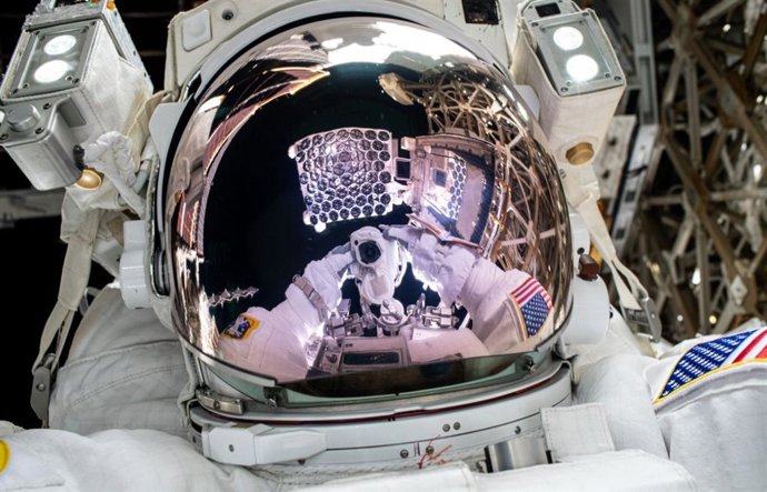 El telescopio de rayos X NICER  se refleja en la visera del casco del traje espacial del astronauta de la NASA e ingeniero de vuelo de la Expedición 72, Nick Hague, en esta "selfi espacial" de