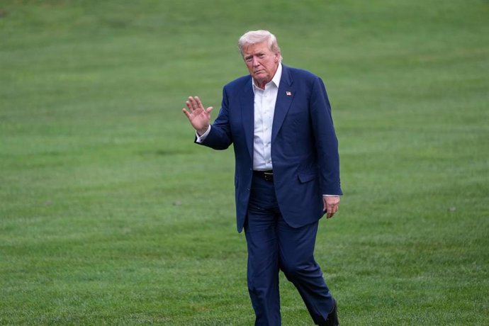 El presidente de EEUU, Donald Trump, saluda a la prensa a la vuelta de su viaje a Escocia.