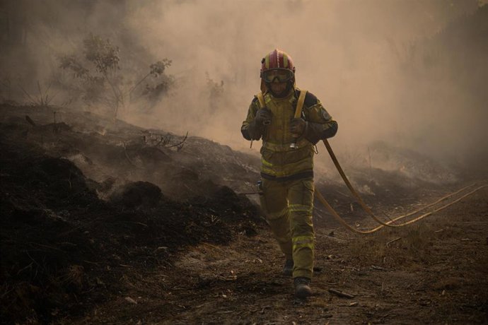 Un bombero trabaja en la extinción de un incendio en Parada del Monte, Portugal