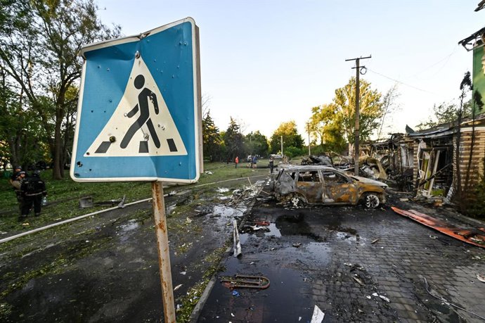 Archivo - Arquivo - 29 de junho de 2024, Vilniansk, região de Zaporizhzhia, Ucrânia: VILNIANSK, UCRÂNIA - 29 DE JUNHO DE 2024 - O sinal de travessia de pedestres é visto perto de carros destruídos pelo ataque de mísseis russos no centro de Vilniansk, regi