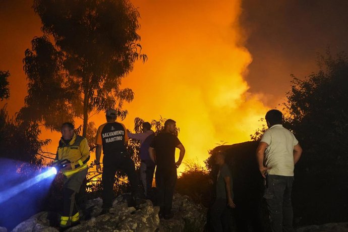 Varias personas tratan de extinguir el fuego, a 5 de agosto de 2025, en Ponteceso, A Coruña, Galicia (España). Un nuevo incendio en el municipio coruñés de Ponteceso ha obligado este martes a desalojar a vecinos de la parroquia de Corme Aldea. Fuentes de 