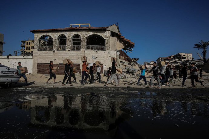 Archivo - June 16, 2025, Gaza City, Gaza Strip, Palestinian Territory: Palestinians carry food parcel, distributed by 'Gaza Humanitarian Relief Foundation' as people struggle with hunger during ongoing Israeli attacks in Gaza City on June 16, 2025. Palest