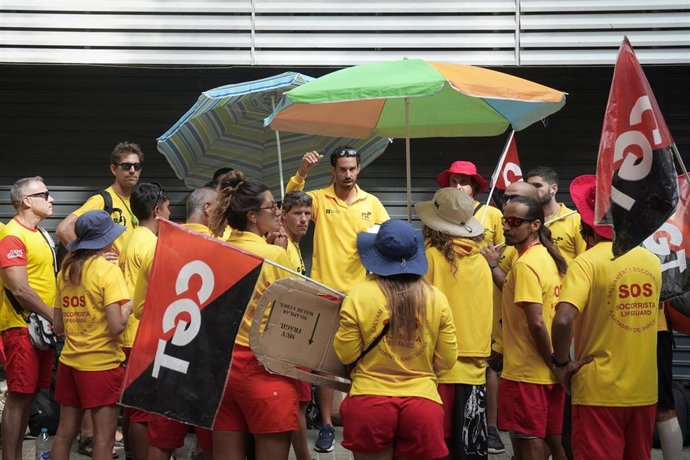 Varias personas protestan durante la huelga indefinida de los socorristas en Barcelona, frente a la sede del PSC, a 4 de agosto de 2025, en Barcelona, Catalunya (España)