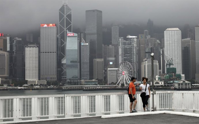 5 de agosto de 2025, Hong Kong, CHINA: Em Hong Kong, um casal fica no topo do Ocean Centre, na orla de Victoria Harbour, durante um intervalo de chuva forte. Hong Kong foi atingida por uma chuva torrencial recorde que durou 11 horas ininterruptas, causand
