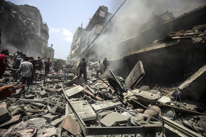 Un grupo de civiles camina entre los escombros de un edificio en ciudad de Gaza