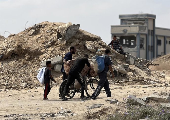 8 de agosto de 2025, Nusairat, Faixa de Gaza, Território Palestino: Palestinos deslocados lutando contra a fome se reúnem em um ponto de distribuição de ajuda montado no Corredor Netzarim na esperança de receber ajuda humanitária limitada em Deir al Balah