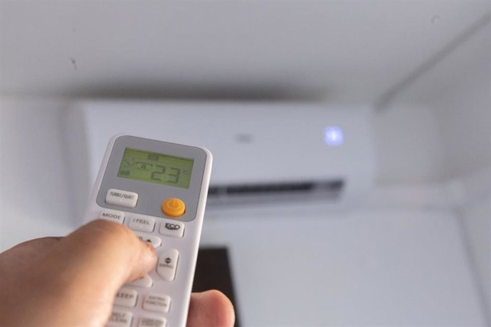 Una persona enciende el aire acondicionado.