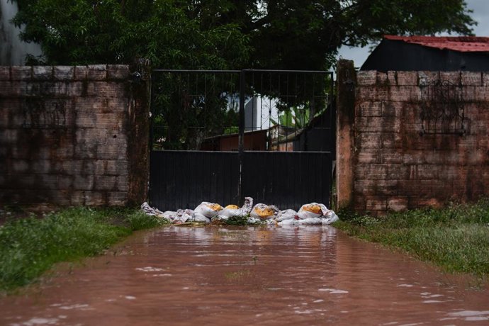 Archivo - Arquivo - 20 de maio de 2022, Villavicencio, Meta, Colômbia: Pessoas colocam sacos de areia para evitar que a água inunde suas casas, enquanto a população de Villavicencio, Colômbia, reage e fica em abrigos depois que o rio Guatiquia transbordou
