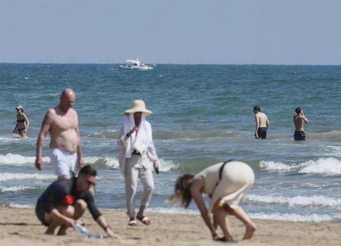 Archivo - Varias personas caminan por la playa de la Malvarrosa, a 26 de abril de 2023, en Valencia