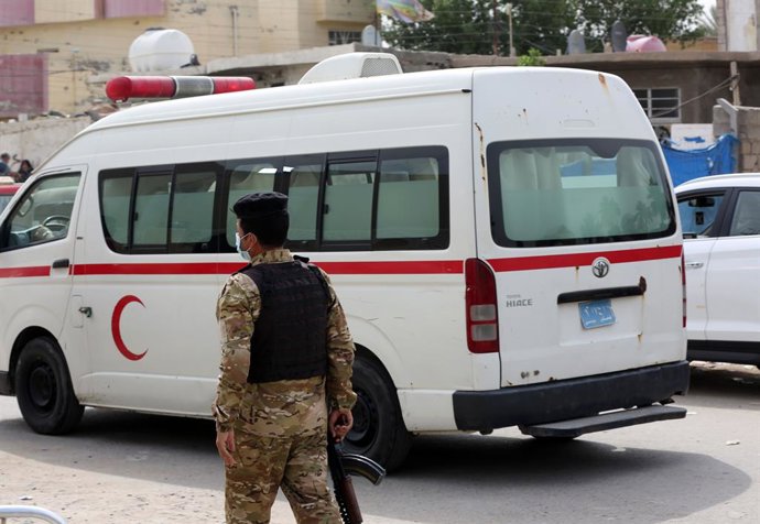 Archivo - (210425) -- BAGDÁ, 25 de abril de 2021 (Xinhua) -- Um policial passa por uma ambulância durante o incêndio no Hospital Ibn al-Khatib em Bagdá, Iraque, em 25 de abril de 2021. O número de mortos em um incêndio de grandes proporções que irrompeu n