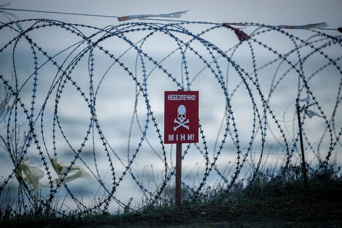 Archivo - Imagen de archivo de alambre de púas y señal de minas en una playa de Odesa