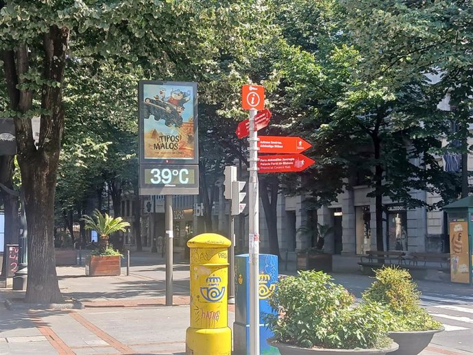 Un térmometro marca 39 grados en una calle.