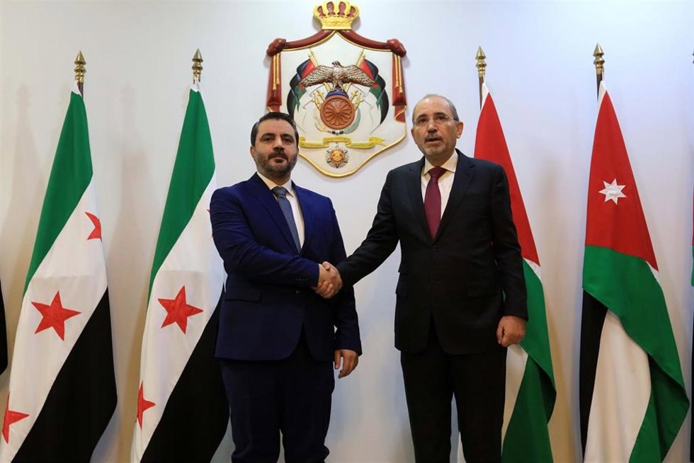 Archivo - El ministro de Exteriores de Siria, Asaad al Shaibani, estrecha la mano de su homólogo jordano, Ayman Safadi, en Ammán, Jordania