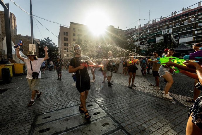 Varias personas durante una batalla de agua, en la Plaza Arturo Barea, a 10 de agosto de 2025, en Madrid (España). 