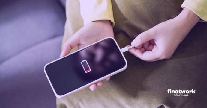 Persona cargando un smartphone con la batería gastada