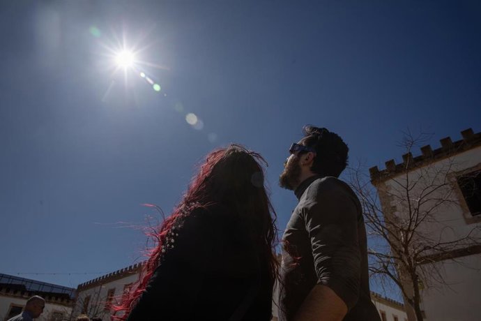 Archivo - 29 March 2025, Spain, Inca: Maria and Adrian observe the sun during the partial solar eclipse in Majorca. Photo: Clara Margais/dpa