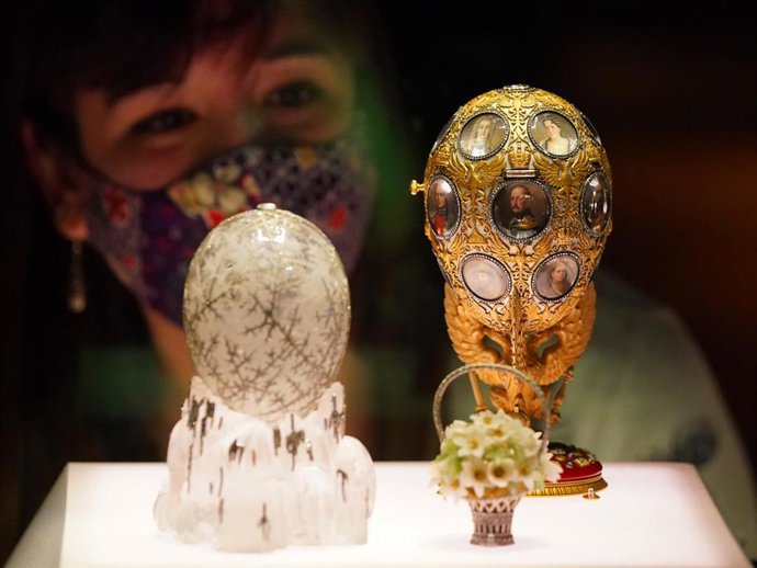 Archivo - 17 November 2021, United Kingdom, London: A museum employee looks at a display case containing the Winter Egg and the Romanov Tercentenary Egg during a photo call for the Victoria and Albert Museum's forthcoming exhibition "Faberge in London: Ro