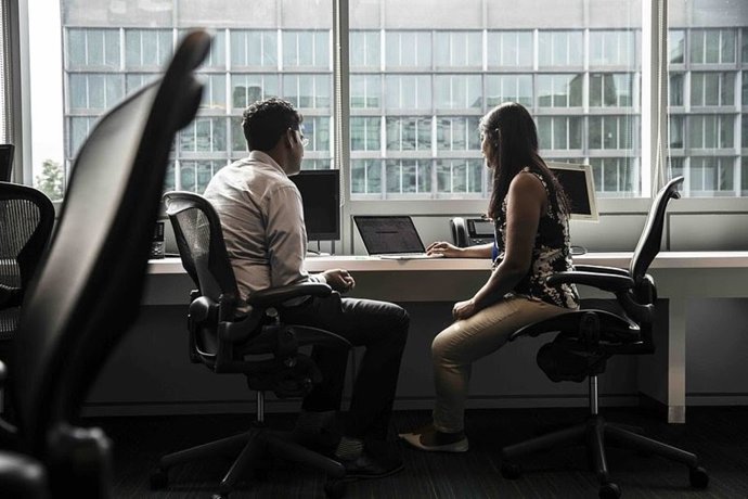 Dos empleados en la oficina usando IA