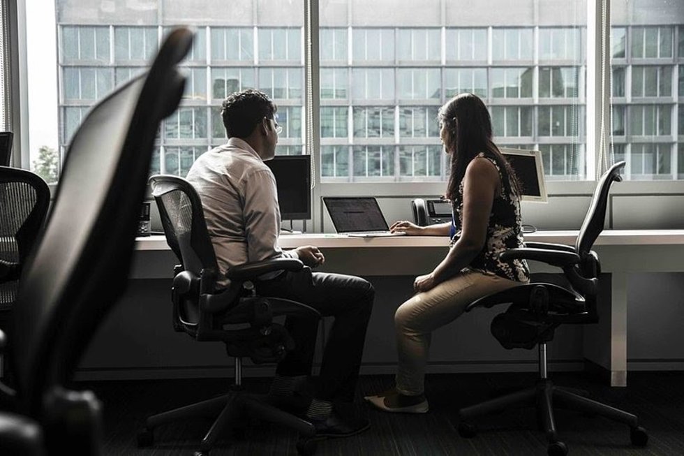 Dos empleados en la oficina usando IA