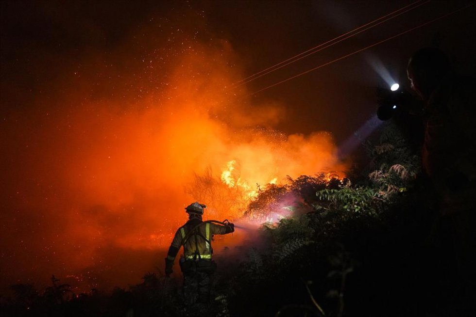 Un bombero trata de extinguir el fuego.