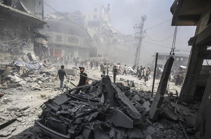 Civiles palestinos inspeccionan una zona atacada por Israel en la ciudad de Gaza