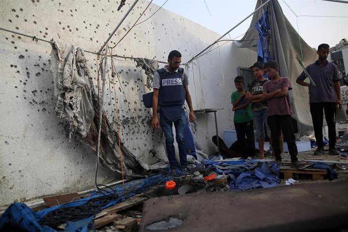Periodistas observan entre los restos tras el ataque de Israel contra su tienda de campaña en ciudad de Gaza