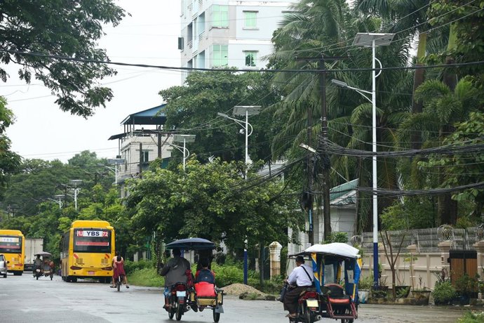 Varios vehículos circulan por una calle de Rangún, en Birmania