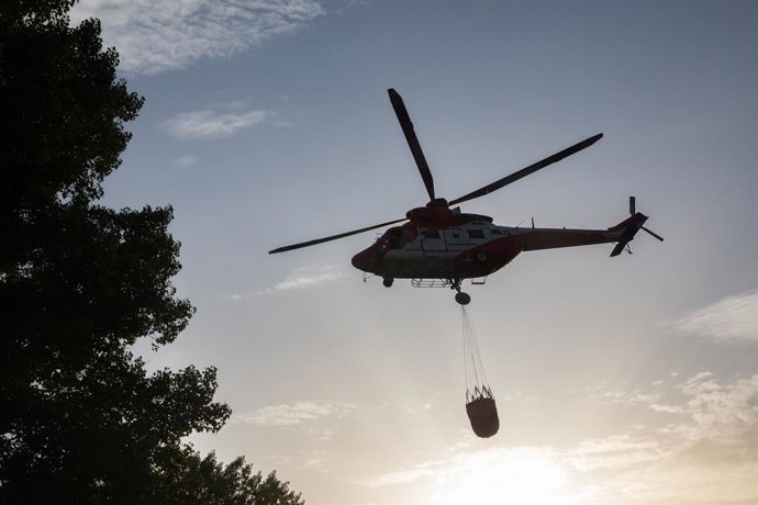 Un helicóptero trabaja en las labores de extinción del incendio, a 12 de agosto de 2025, en Tres Cantos, Madrid (España). El incendio de vegetación registrado a última hora de la tarde de este lunes, 11 de agosto, en Tres Cantos ha evolucionado favorablem
