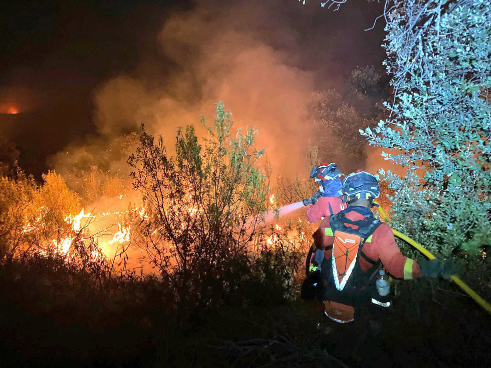 Dos agentes de la Unidad Militar de Emergencias (UME) trabajan en las labores de extinción del incendio, a 12 de agosto de 2025, en Tres Cantos, Madrid (España).