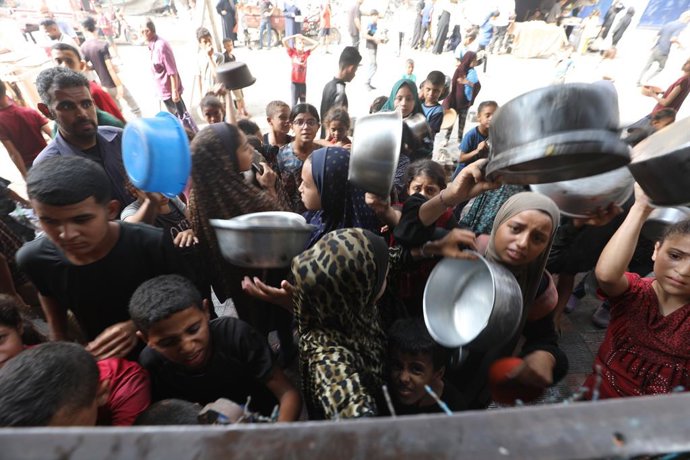 12 de agosto de 2025, Bureij, Faixa de Gaza, Território Palestino: Palestinos esperam para receber alimentos de uma cozinha beneficente, em meio a uma crise de fome, em Bureij, no centro da Faixa de Gaza, em 12 de agosto de 2025,Image: 1028982666, Licença