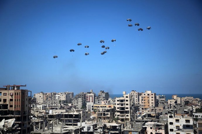 06 August 2025, Palestinian Territories, Gaza: A German military aircraft loaded with humanitarian aid drops supplies over Gaza, as seen from the northern Gaza Strip. Photo: Omar Ashtawy/APA Images via ZUMA Press Wire/dpa